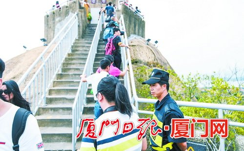 _在日光岩上，保安引导游客有序通行。.jpg